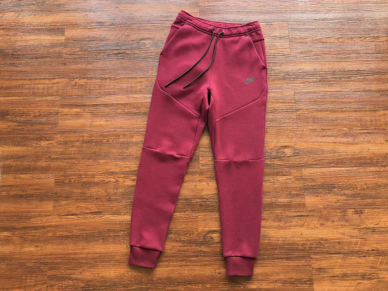 NIKE Tech Fleece Pants - Burgundy - Red Unisex Streetwear Limited Edition - The NIKE TECH FLEECE PANTS BURGUNDY - REPLICA bring together modern athletic performance and bold