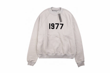 Fear Of God Essentials '1977' Sweatshirt - Grey Unisex Streetwear Limited Edition - This Fear of God Essentials sweatshirt features a minimalist design with the bold '1977' graphic