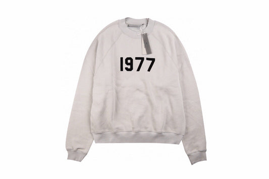Fear Of God Essentials '1977' Sweatshirt - Grey Unisex Streetwear Limited Edition - This Fear of God Essentials sweatshirt features a minimalist design with the bold '1977' graphic