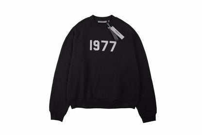Essentials Sweatshirt - Black Unisex Streetwear Limited Edition - Black sweatshirt with white '1977' print on the chest. Classic crewneck design. Comfortable and perfect