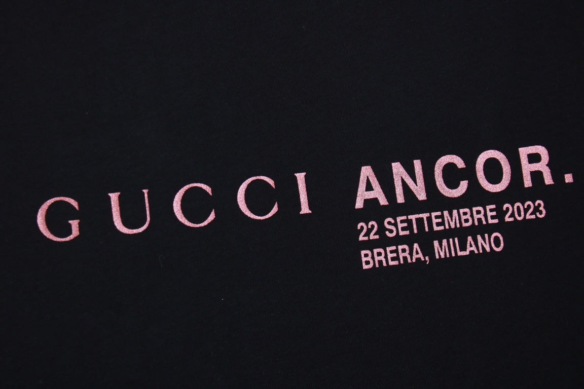 Gucci Ancor. T-shirt (black) Unisex Streetwear Limited Edition - <span>Stylish black t-shirt featuring a red 'GUCCI ANCOR.' graphic with event details on the chest.