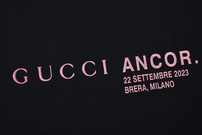 Gucci Ancor. T-shirt (black) Unisex Streetwear Limited Edition - <span>Stylish black t-shirt featuring a red 'GUCCI ANCOR.' graphic with event details on the chest.