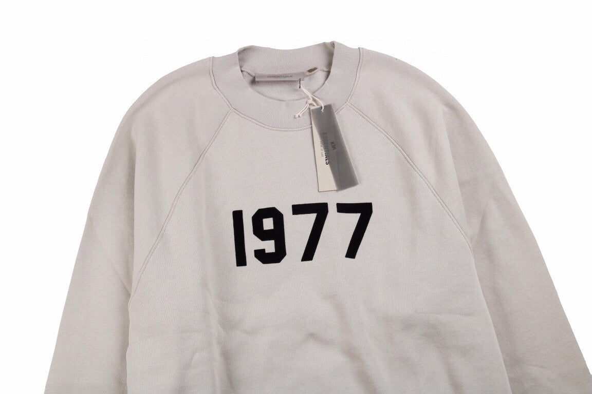 Fear Of God Essentials '1977' Sweatshirt - Grey Unisex Streetwear Limited Edition - This Fear of God Essentials sweatshirt features a minimalist design with the bold '1977' graphic
