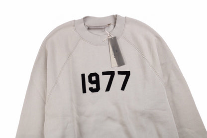 Fear Of God Essentials '1977' Sweatshirt - Grey Unisex Streetwear Limited Edition - This Fear of God Essentials sweatshirt features a minimalist design with the bold '1977' graphic