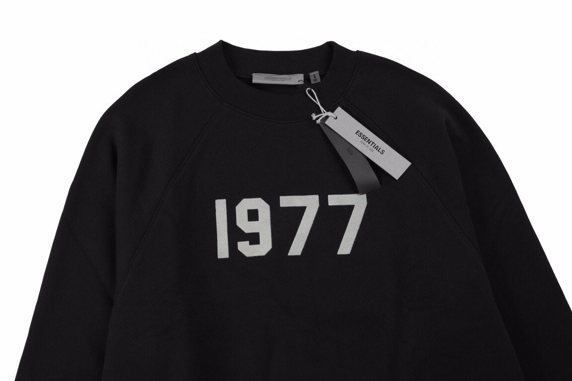 Essentials Sweatshirt - Black Unisex Streetwear Limited Edition - Black sweatshirt with white '1977' print on the chest. Classic crewneck design. Comfortable and perfect