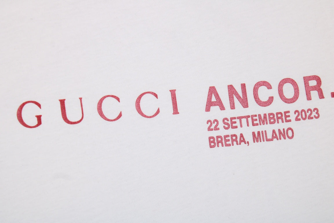 Gucci Ancor. T-shirt (white) Unisex Streetwear Limited Edition - <span>Stylish white t-shirt featuring a red 'GUCCI ANCOR.' graphic with event details on the chest.