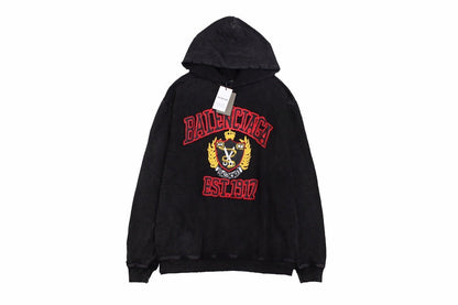 Balenciaga Crest Hoodie - Black Unisex Streetwear Limited Edition - This Balenciaga hoodie features a prominent crest design in red and gold, highlighting the brand's