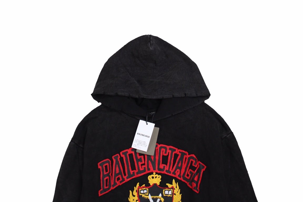 Balenciaga Crest Hoodie - Black Unisex Streetwear Limited Edition - This Balenciaga hoodie features a prominent crest design in red and gold, highlighting the brand's